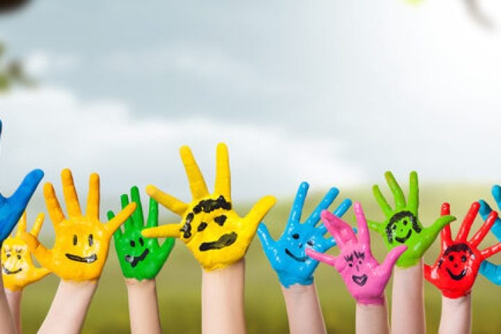 colorful painted hands in front of a spring scene